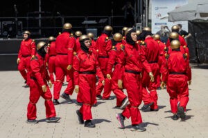 Die Roboter: eine Gruppe in roten Uniformen gekleideter Menschen mit goldenen Helmen auf der Straße