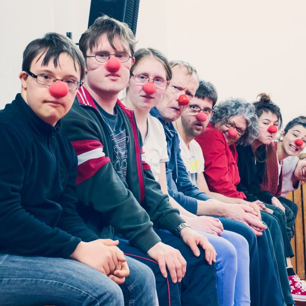 a group of people with red noses sitting next to each other